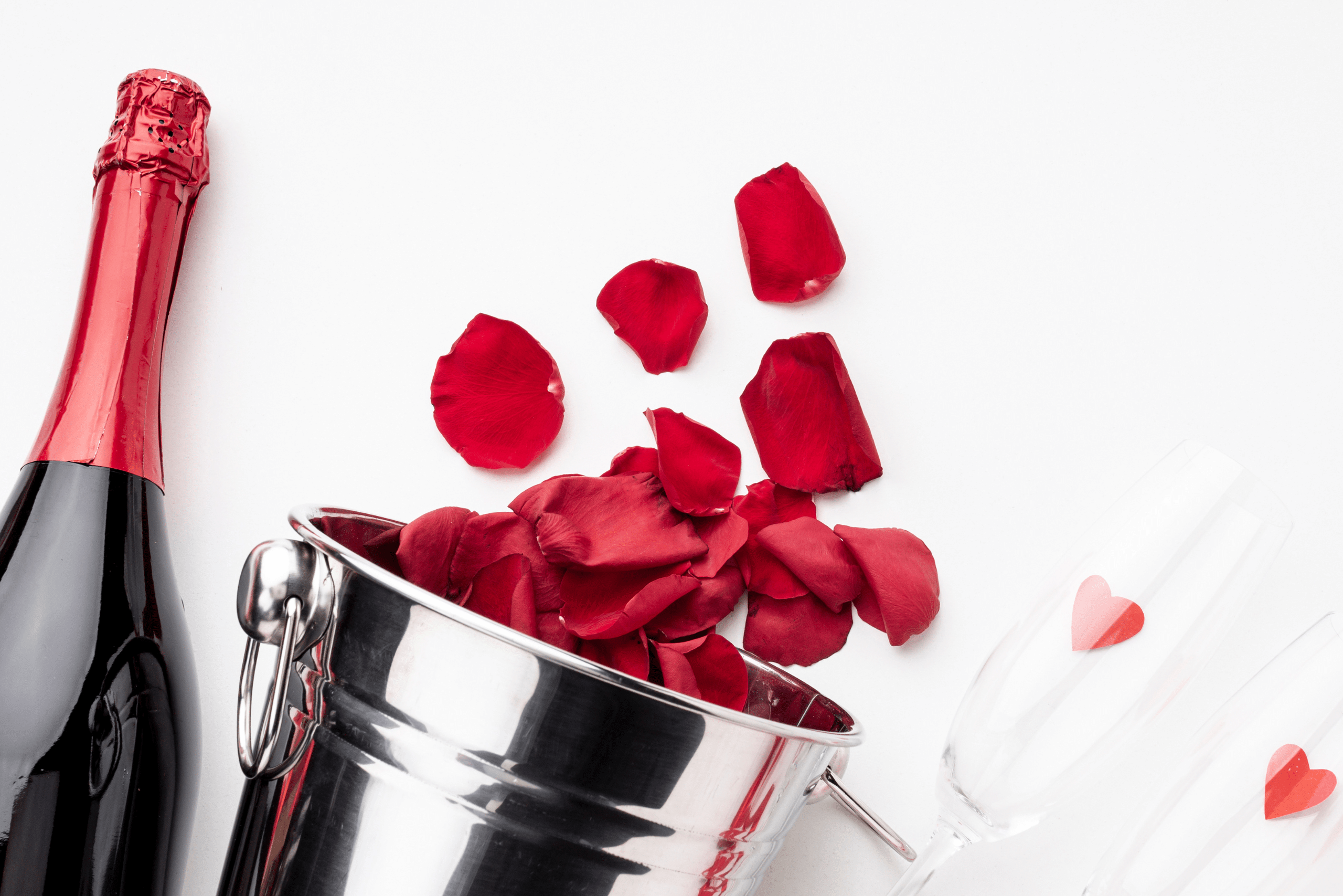 Bouteille, verres de champagne et pétales de roses